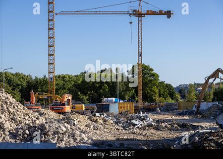 Posen, Polen – 30. Juni 2025: Eine geschäftige Baustelle mit riesigen gelben Kränen, schweren Baggern und Schutthaufen veranschaulicht urba Stockfoto