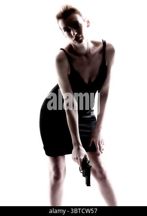Eine Frau in einem schwarzen Kleid hält eine Waffe. Stockfoto