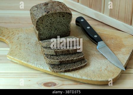 Ein Brotlaib auf einem hölzernen Schneidebrett. Stockfoto