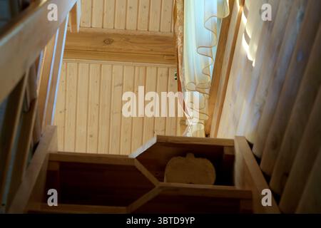 Ein Blick auf eine Holztreppe in einem Haus, von unten gesehen. Stockfoto