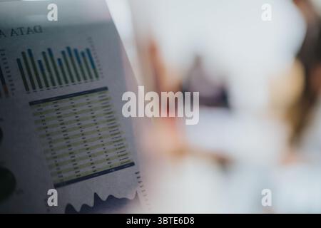 Nahaufnahme von Finanzdaten-Diagrammen mit verschwommenem Hintergrund in einem Co-Working-Café Stockfoto