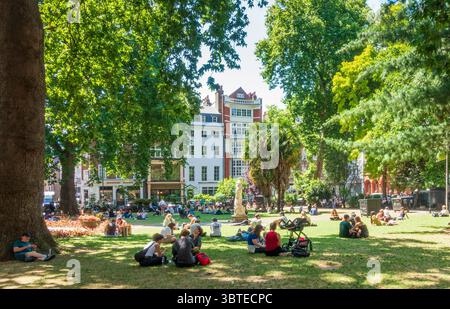 Menschen, die sich an einem Sommertag am Soho Square, London, entspannen Stockfoto