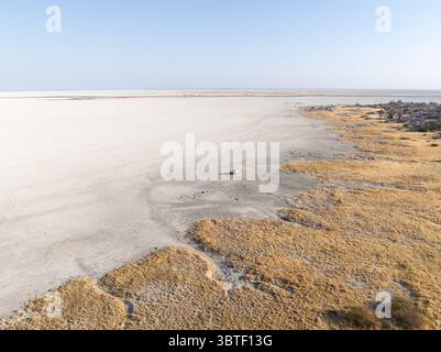Felsige Insel mit Baobab-Bäumen in einer trockenen Salzpfanne, Geländefahrzeug auf der Salzpfanne, Blick aus der Vogelperspektive, Insel Kubu, Sowa Pfanne, Salzpfannen Makgadikgadi, Botswa Stockfoto