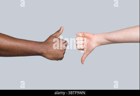 afroamerikaner Daumen hoch, kaukasier zeigen Daumen nach unten. Ich mag nicht gerne eine Geste. Rassentoleranz. Problemkooperation. Weiß weiblich und schwarz Stockfoto