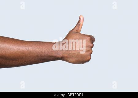 Wie eine Geste. Nahaufnahme Hand zeigt Daumen nach oben. Mannhände zeigen Daumen hoch. Unterstützen Sie ermutigen. Afrikanische männliche Hand mit Daumen nach oben. afroamerikaner Stockfoto