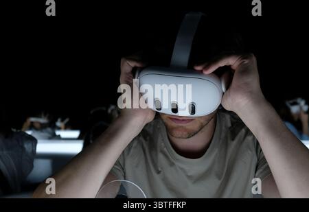 Mann mit Virtual-Reality-Headset in einem dunklen Raum Stockfoto