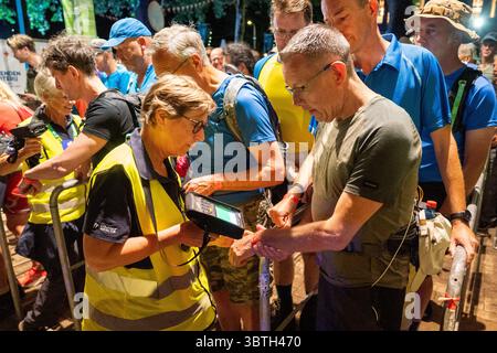 Nijmegen, Niederlande. Juli 2025. NIJMEGEN, NIEDERLANDE - 15. JULI: Tag 1 der vier-Tage-Märsche (Vierdaagse/4daagse), der weltweit größten mehrtägigen Wanderveranstaltung mit über 47,000 Teilnehmern. Das Foto zeigt einen Mitarbeiter, der das Armband eines der Gehhilfen zu Beginn scannt und registriert. Am 15. Juli 2025 in Nijmegen, Niederlande. (Foto von John Beckmann/Orange Pictures) Credit: Orange Pics BV/Alamy Live News Stockfoto