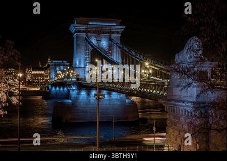 Die legendäre Széchenyi Kettenbrücke leuchtet bei Nacht blau über der Donau, ein atemberaubendes Symbol für Budapests Schönheit und Geschichte. Budapest, Ungarn, März, Stockfoto
