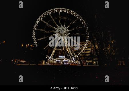 Beleuchtetes Riesenrad, das am Nachthimmel in der Innenstadt von Budapest, Ungarn, März 2025 leuchtet Stockfoto