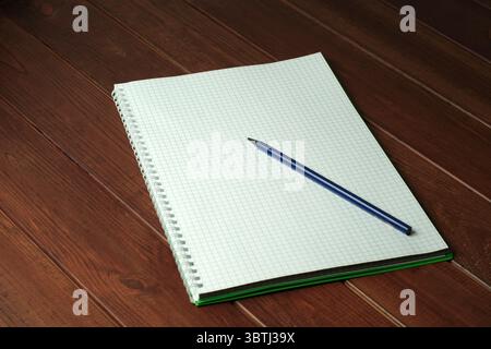 Ein einfaches Notizbuch liegt offen auf einem Holztisch und lädt zu neuen Ideen und Gedanken ein. Stockfoto