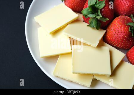 London UK, 15. Juli 2025, frisch reife Bio-Erdbeeren mit weißen Schokoladenquadraten Stockfoto