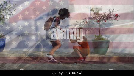 Zwei Frauen, die Skateboard balancieren und das Smartphone auf Bordsteinkante benutzen, Rucksäcke mit Fahnenüberzug tragen Stockfoto