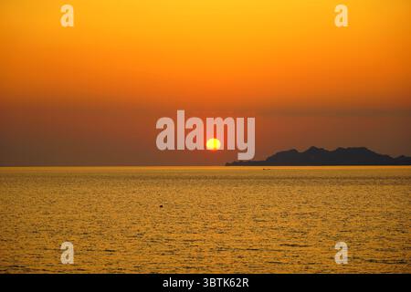 Sonnenuntergang über dem Golf von Korinth vom Ufer von Loutraki in Zentralgriechenland Stockfoto