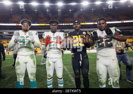28. Oktober 2019, Pittsburgh, Pennsylvania, USA: Miami Dolphins Defensive End Trent Harris (97), Miami Dolphins Wide Receiver Allen Hurns (17), Pittsburgh Steelers Cornerback Artie Burns (25) und Miami Dolphins Running Back Mark Walton (22) posieren nach dem Spiel für die Kamera. (Kreditbild: © Brian Kunst/ZUMA Wire) Stockfoto