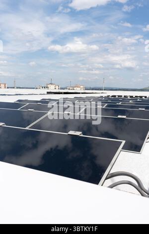 Auf dem Dach des Gebäudes sind Solarpaneele installiert. Eine große Anzahl von Solarpaneelen in einem Industriegebäude. Stockfoto