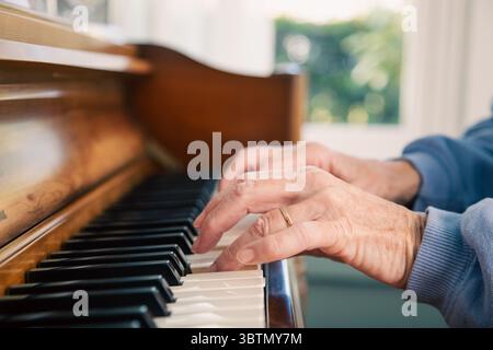 Nahaufnahme der Hände einer älteren Frau, die Klavier spielen Stockfoto