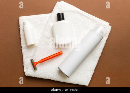 Rasierer-Set. Schermaschine, Handtuch, Lotion und Rasierschaum auf farbigem Hintergrund. Herren Bad Accessoires Draufsicht. Stockfoto