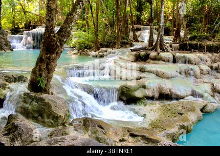 Der mehrstufige Wasserfall fließt in türkisfarbene Pools im Erawan Nationalpark, Thailand, umgeben von üppigen Wäldern in einer ruhigen natürlichen Umgebung Stockfoto