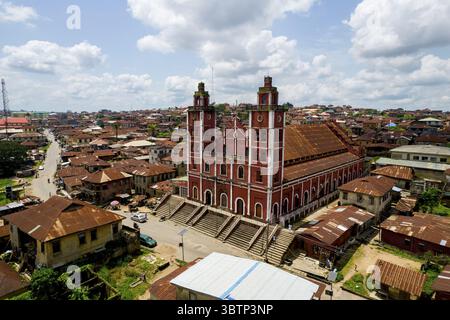 Majestätisch erhebt sich der Blick auf die große, rot-weiße Kathedrale aus der Vogelperspektive, ein lebhafter Kontrast zu den rostigen Dächern darunter, Abeokuta, Ogu Stockfoto
