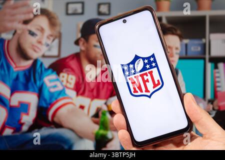 BOGOTA, KOLUMBIEN - 14. JULI 2025 Eine männliche Hand, die ein Smartphone mit dem Logo der National Football League oder NFL hält und ein verschwommenes Konzept für Fußballfans bei b Stockfoto