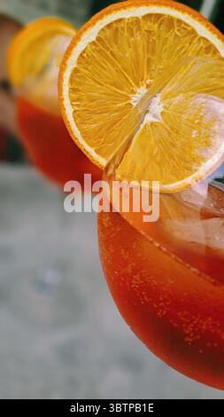 Nahaufnahme eines Aperol Spritz Cocktails mit einer Orangenscheibe in einem Glas. Stockfoto