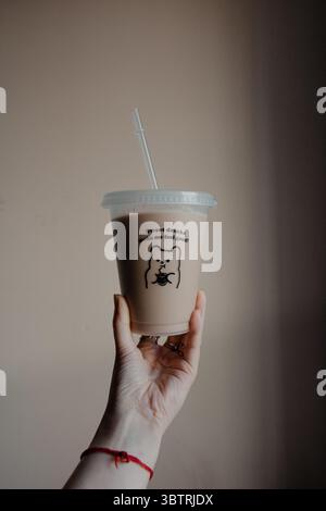 Hand hält Eiskaffee in Plastikbecher Stockfoto