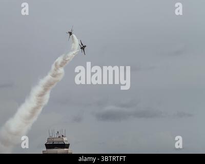 Zwei USAF Thunderbirds F-16 führen während einer Flugschau am 16. Mai 2025 einen gegensätzlichen Solo-Aufstieg mit Rauchpfaden über McGuire AFB durch. Stockfoto