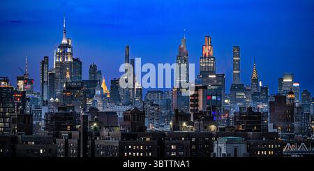 New York City Skyline nach dem 4. Juli nachts mit Wolkenkratzern/Gebäuden und Architektur - Downtown Manhattan von Brooklyn aus gesehen Stockfoto