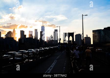 Brooklyn Bridge Traffic - Autos bei Sonnenuntergang Abend und Nacht Herbst - Nahaufnahme von Kabeln und Steinbögen in Lower Manhattan New York City Stockfoto