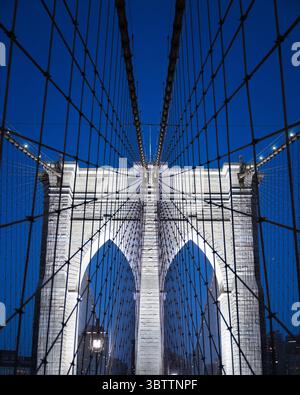Brooklyn Bridge Details während Sonnenuntergang Abend und Nacht Nahaufnahme von Kabeln und Steinbögen in Lower Manhattan New York City in der Abenddämmerung Stockfoto