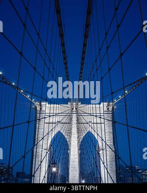 Brooklyn Bridge Details während Sonnenuntergang Abend und Nacht Nahaufnahme von Kabeln und Steinbögen in Lower Manhattan New York City in der Abenddämmerung Stockfoto