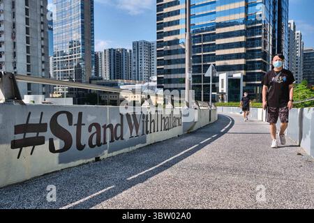 18. Oktober 2020, Hongkong, China: Ein Mann mit Gesichtsmaske geht an einem Graffiti in Hongkong vorbei. Die Aktivisten von Hongkong haben in den sozialen Medien ihre Solidarität mit der Demokratiebewegung Thailands mit den Hashtags "#StandWithThailand"" und "#MilkTeaAlliance"" zum Ausdruck gebracht, die auf eine Koalition asiatischer Pro-Demokratie-Aktivisten verweisen. (Kreditbild: © Isaac Wong/SOPA Images via ZUMA Wire) Stockfoto