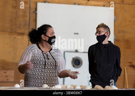 18. Oktober 2020, Tieton, Washington, USA: MARGARITA GONZALEZ zeigt einem jungen Besucher, wie man Zuckerschädel mit alfeÃ±ique im Mighty Tieton Warehouse in Tieton, Washington, am Sonntag, den 18. Oktober 2020 herstellt. Die traditionellen mexikanischen Süßigkeiten werden bei der Tieton Arts & Humanities Dia de los Muertos Community Celebration geteilt, die jährlich stattfindet, um an verstorbene Freunde und Familienmitglieder zu erinnern und ihre spirituelle Reise zu unterstützen. (Foto: © Paul Christian Gordon/ZUMA Wire) Stockfoto