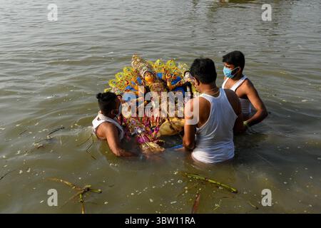 26. Oktober 2020, Kolkata, Westbengalen, Indien: Eine Familie taucht ein Idol von Durga in den Fluss ganges ein, um das Ende des Durga Puja Festivals zu feiern. Heute ist das Ende des 7-tägigen Festivals Durga Puja in Kolkata mit dem Eintauchen des Idol der Göttin Durga in den Fluss Ganges. (Bild: © Debarchan Chatterjee/ZUMA Wire) Stockfoto
