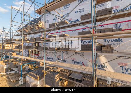 Gerüstbau um das Haus und Ziegelsteinarbeiten Stockfoto