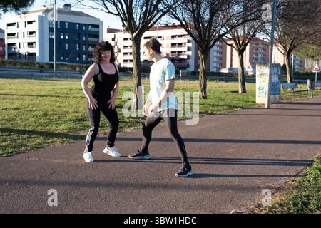 Personal Trainer, der reife Frauen beim Outdoor-Workout im Park begleitet Stockfoto