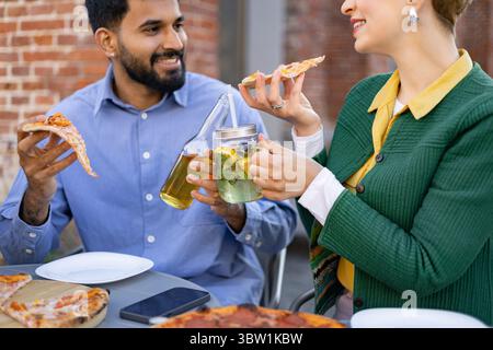 Ein Paar genießt Pizza und Drinks Stockfoto