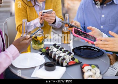 Freunde mögen Sushi und Tech Stockfoto