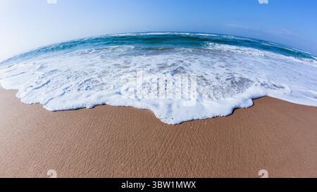 Strand Sandwasser Rand mit Nahaufnahme der weißen Wasserwelle Wash Front der blauen Ozean Landschaft. Stockfoto