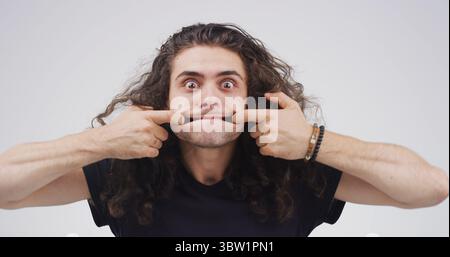 Lustiges Gesicht, Stretching und Porträt des Mannes im Studio für Theatervorbereitung, Gesichtsübungen und Comic. Der Schauspieler wärmt Routine, Ausdruck und Muskel auf Stockfoto