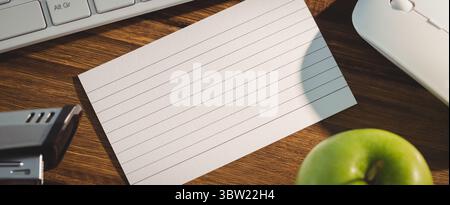 Papier zwischen elektronischen Geräten und Apfel Stockfoto
