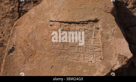 Auf einem verwitterten Stein im Irak Uruk wurde eine alte Inschrift in Keilschrift entdeckt, die Licht auf die mesopotamische Zivilisation und Sprache wirft. Stockfoto