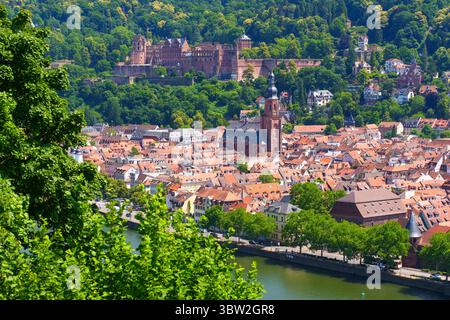 Lebendige Luftaufnahme mit dem Heidelberger Schloss und der Stadt darunter, mit üppigem Grün und dem Neckar. Stockfoto