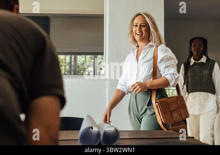 Ein Team von Architekten, darunter eine junge Frau und eine Frau mittleren Alters, arbeitet in einer modernen Büroumgebung zusammen und betont Kreativität und Teamgeist Stockfoto