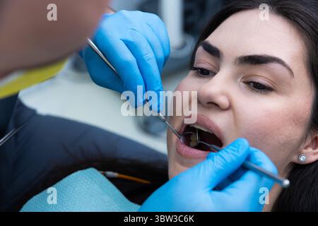 Professionelle zahnärztliche Untersuchung: Nahaufnahme eines Patienten, der in einer Zahnarztpraxis durch einen Fachzahnarzt mit einem Dentalinstrument für eine Zahnarztpraxis versorgt wird Stockfoto