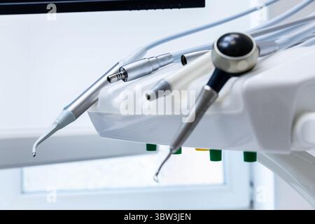 Nahaufnahme eines modernen Dentalgerätes mit verschiedenen Tools für zahnärztliche Eingriffe in einer hellen, sauberen Büroumgebung Stockfoto