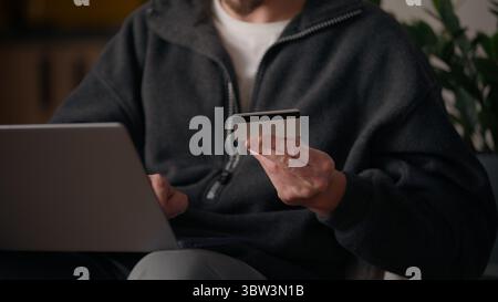 Glücklicher kaukasischer Mann Hipster-Käufer mit Kreditkarte online bargeldlose Zahlung Kredit Internet zufriedener Kunde Tippen männlich Eingabe Daten Laptop at Stockfoto