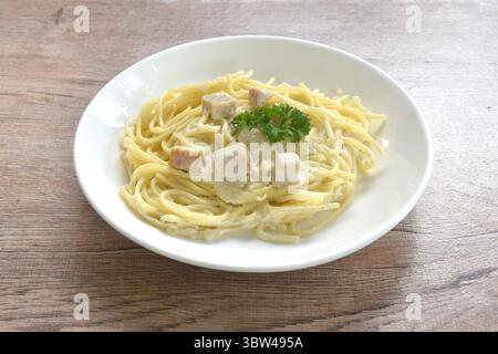 Gedämpfte Spaghetti, weiße Cabonara-Cremesauce, belegt Pilzscheiben auf dem Teller Stockfoto