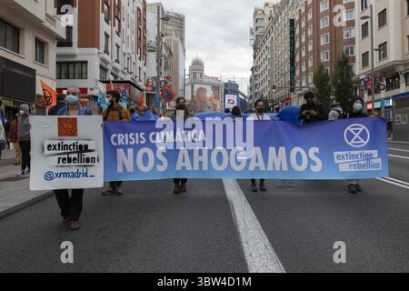 2. November 2020, Madrid, Spanien: Aktivisten in Masken halten ein Banner mit der Aufschrift Klimakrise, wir sinken während der Demonstration. Während der dritten internationalen Rebellion blockierte die Bewegung der Extinction Rebellion die Gran VÃ­a Straße in Madrid, um gegen die Folgen des steigenden Meeresspiegels zu protestieren. Die Bewegung, die ein 150 Quadratmeter großes blaues Tuch vom Callao-Platz zum Spanien-Platz trägt, marschiert über die Gran VÃ­a-Straße, um die wachsende Zahl von Menschen sichtbar zu machen, die vom Anstieg des Meeresspiegels infolge des Klimawandels betroffen sind. Dieser Akt unter dem Namen "Wir sinken" repräsentiert die große Anzahl von Stockfoto