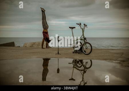 4. November 2020, Barcelona, Katalonien, Spanien: Ein brasilianischer Yoga-Trainer fängt während der zweiten Welle der beschleunigten Ausbreitung des Coronavirus die „Come“-Haltungen für seinen Instagram-Account am Strand Barcelonas ein (Credit Image: © Matthias Oesterle/ZUMA Wire) Stockfoto